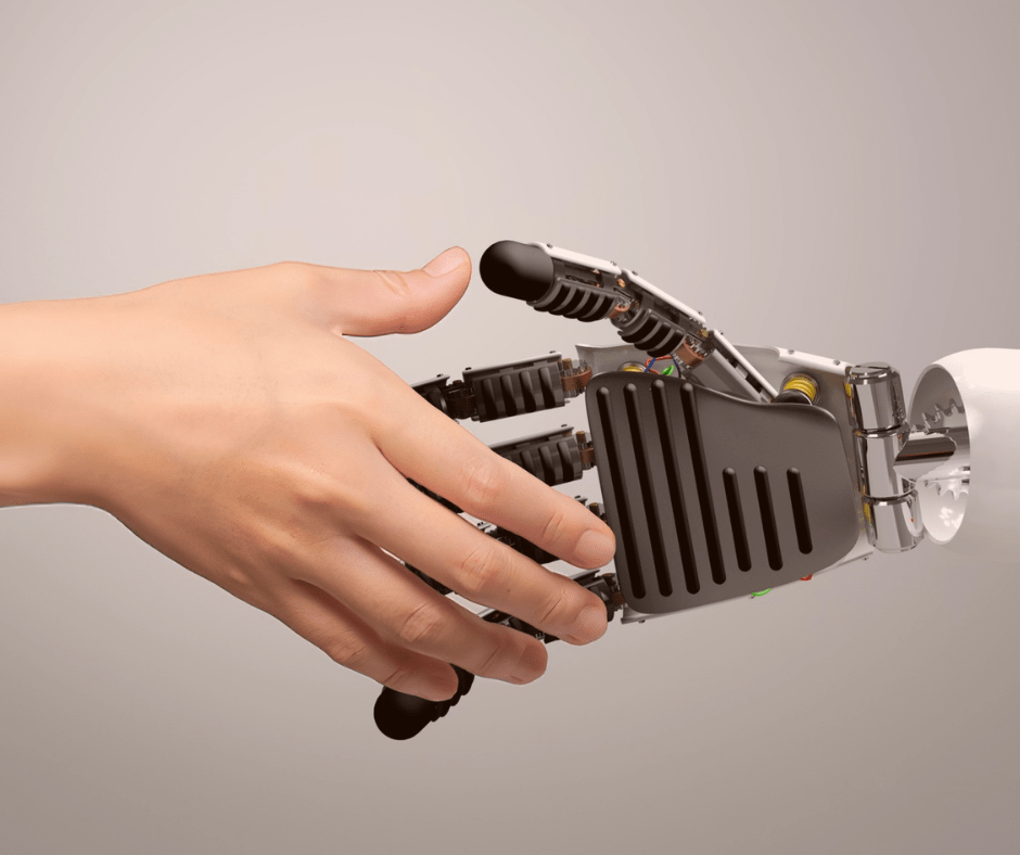 KI und Menschen reichen sich die Hand - eine menschliche Hand und eine Roboterhand machen einen Handschlag